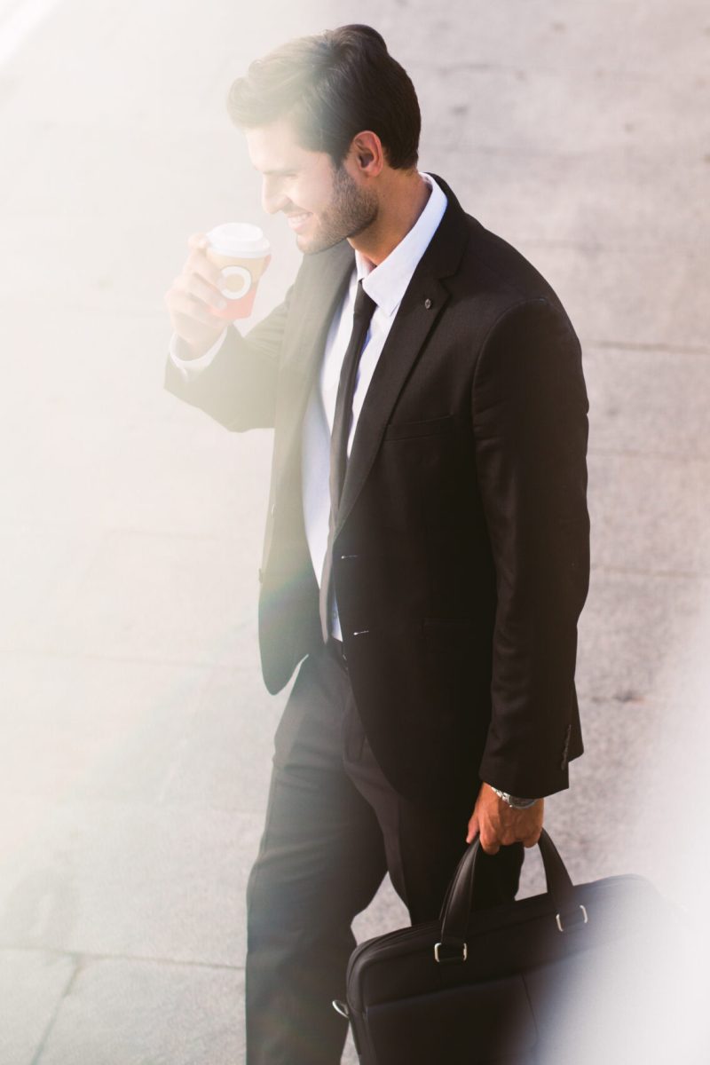 smiling-businessman-drinking-coffee-in-the-street-2023-11-27-05-05-31-utc-scaled.jpg